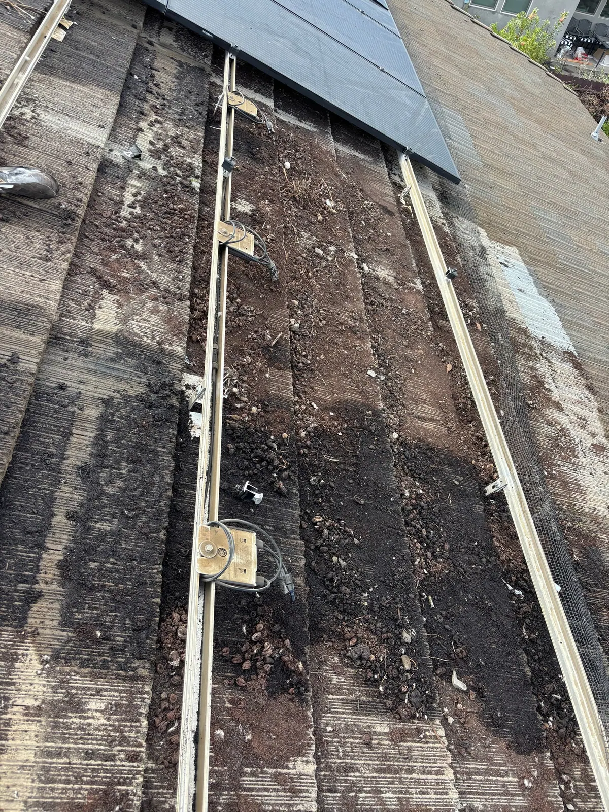 Debris and roof rails visible beneath a partially exposed solar array