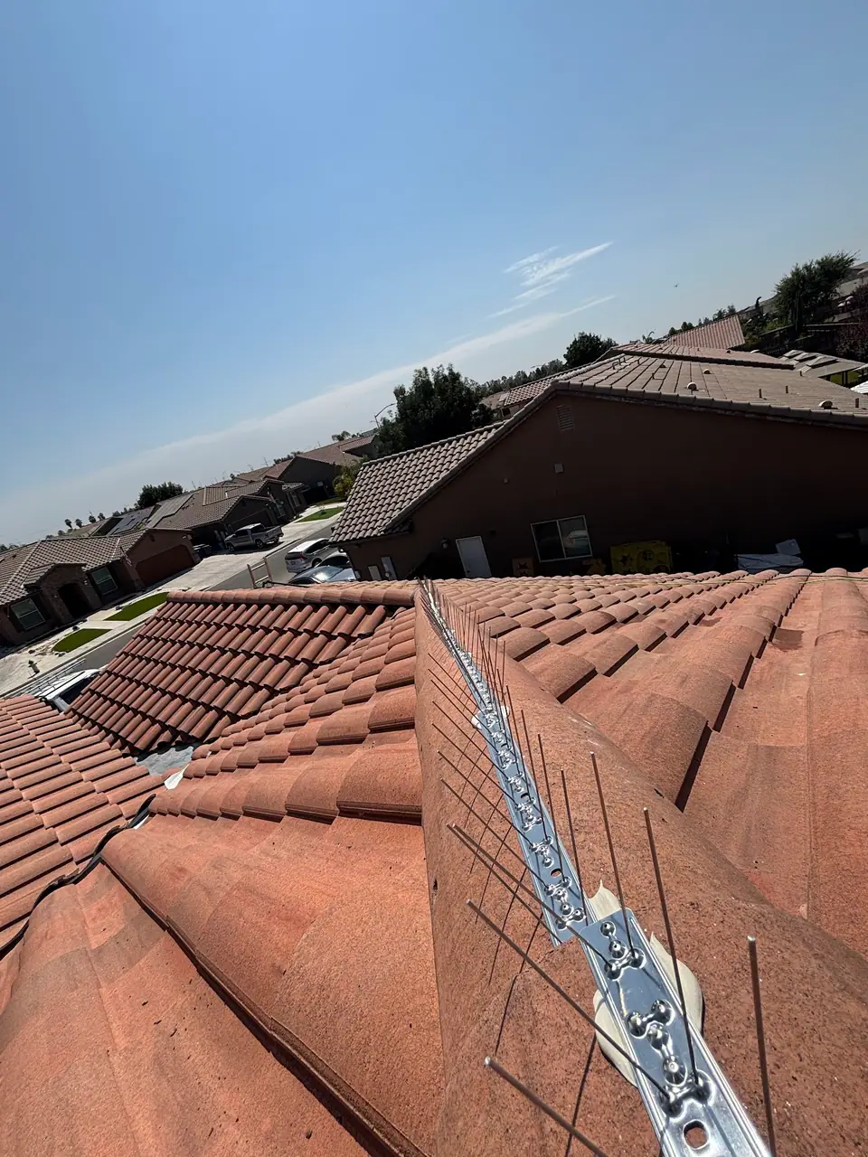 Close view of bird deterrent strips secured along a tile roof ridge