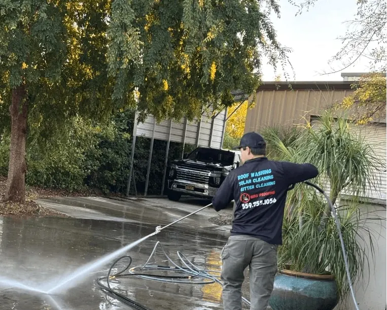 CA Solar Wash technician using washing equipment on exterior paving