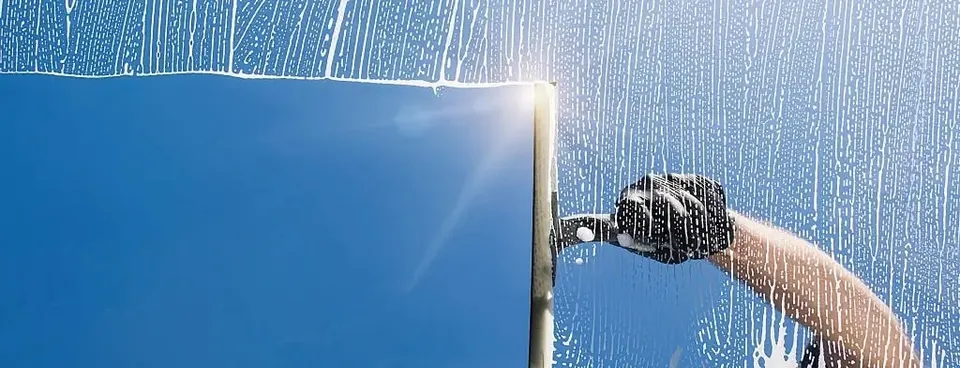 Squeegee clearing soap and water from exterior window glass